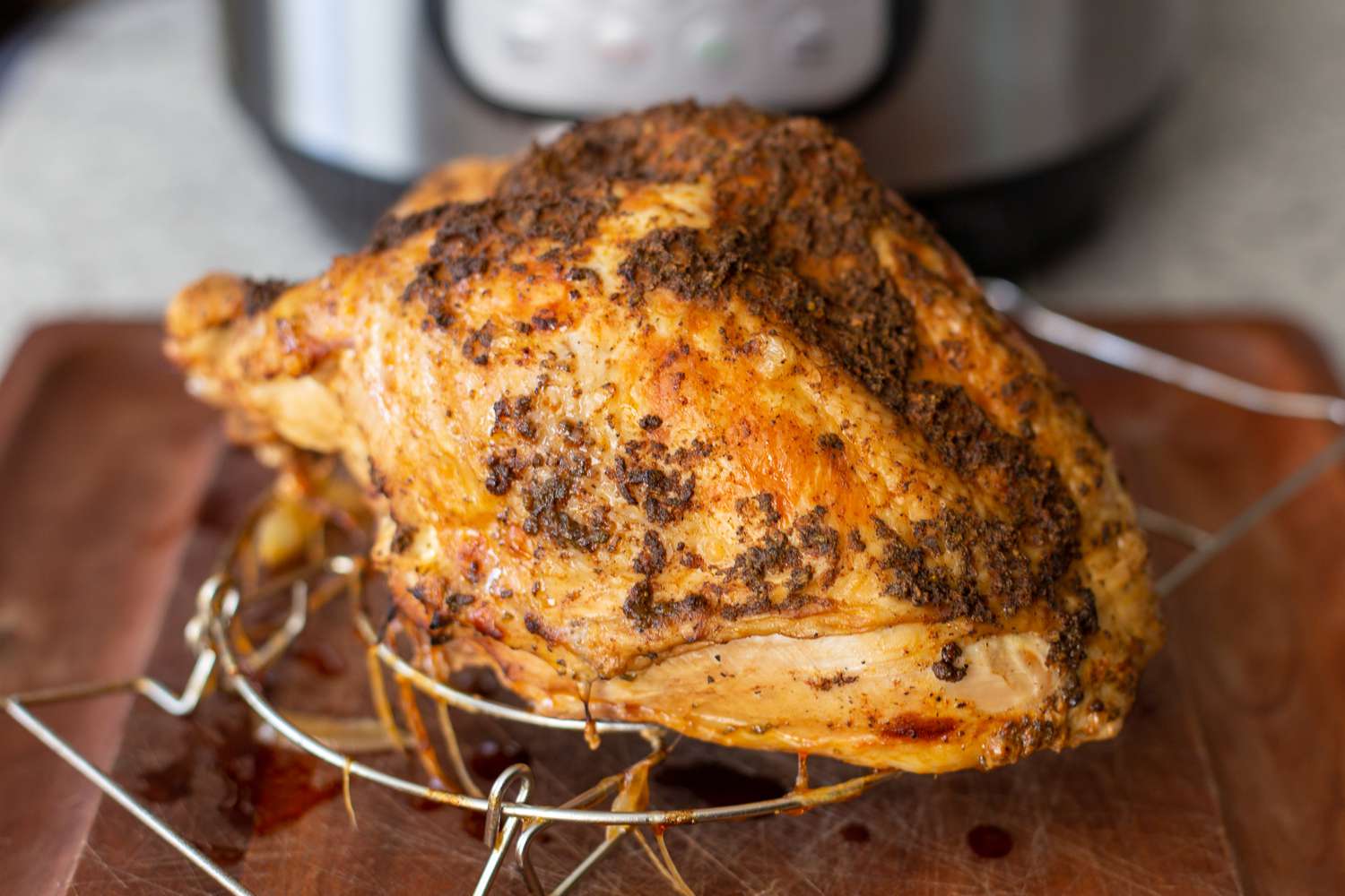 Quick and easy instant pot turkey breasts set on a steam rack on a cutting board in front of an instant pot.