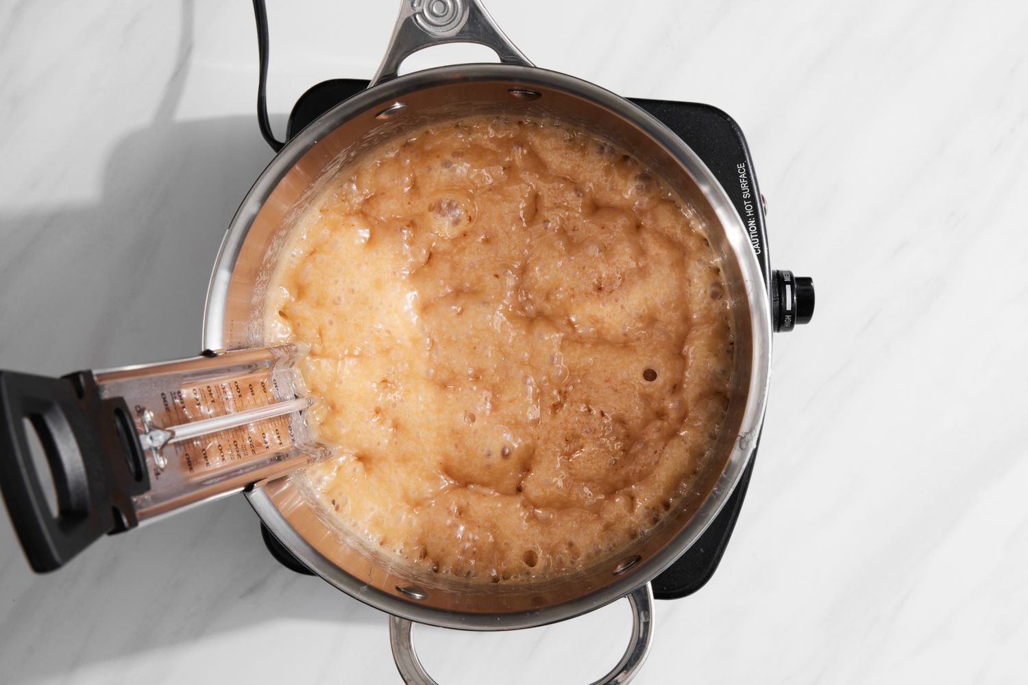 Caramel Boiling in a Pot with a Thermometer for Holiday Candy