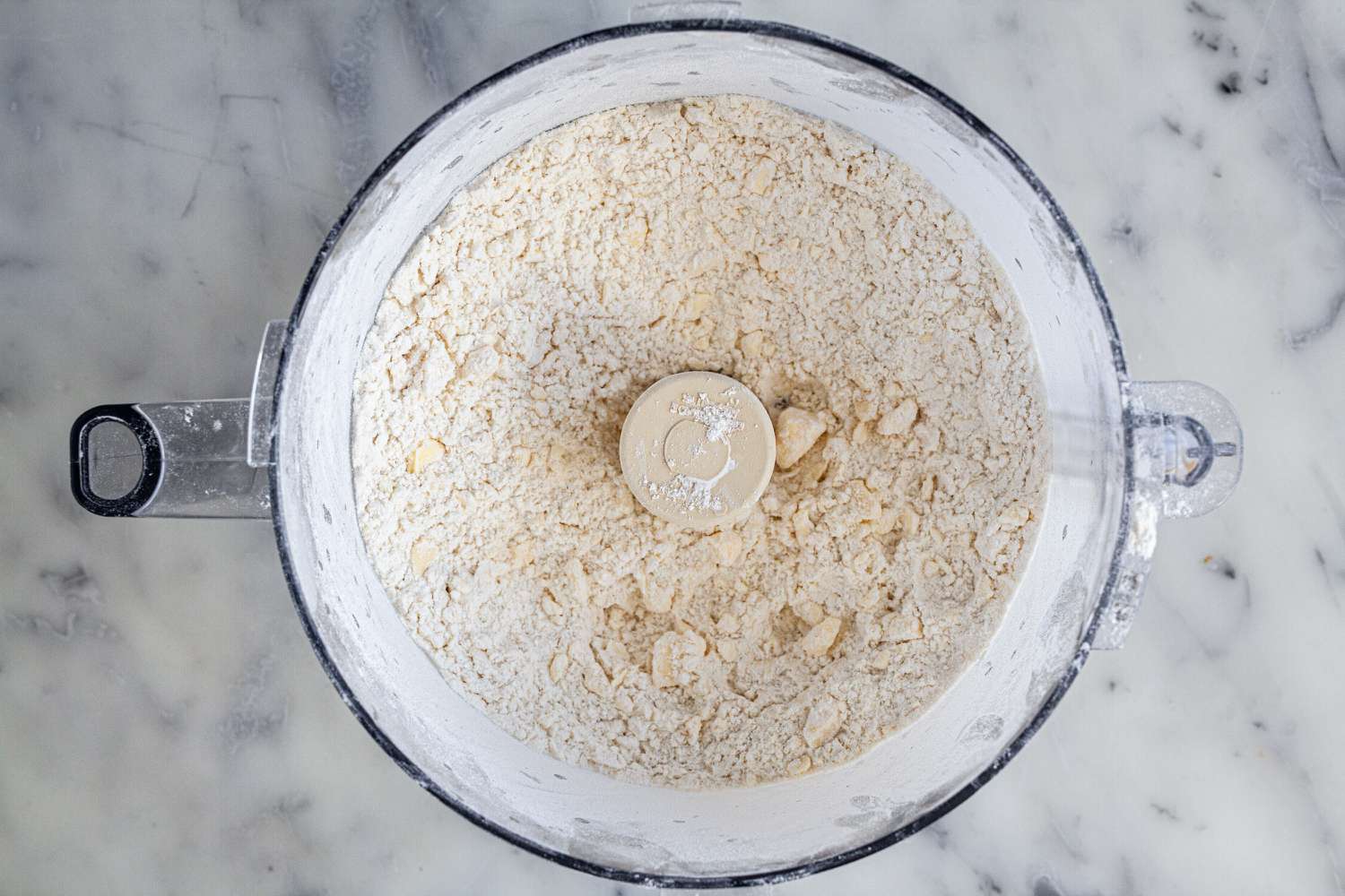 Butter and flour combined in a food processor to show how to make pie crust.