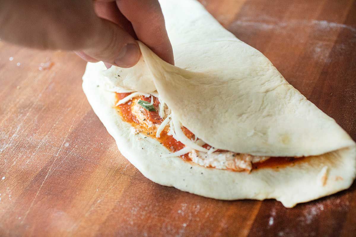 Folding the dough over toppings