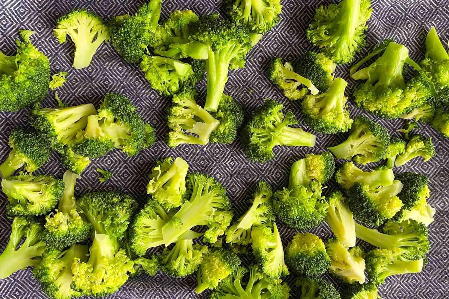 Overhead view of chopped broccoli florets on a towel