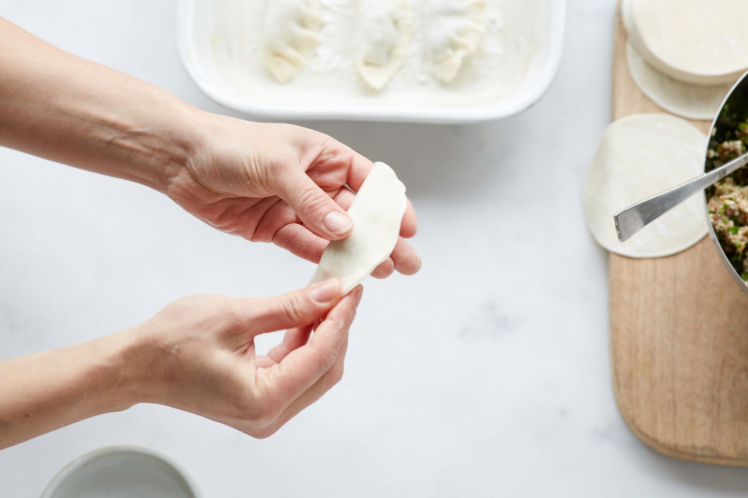 Filling and folding Korean pork and chives dumplings 