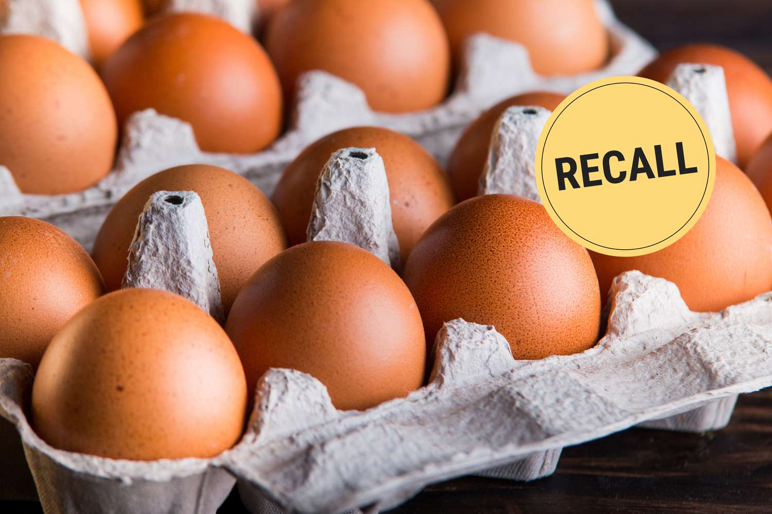 Cartons of brown eggs with a "recall" label over one carton