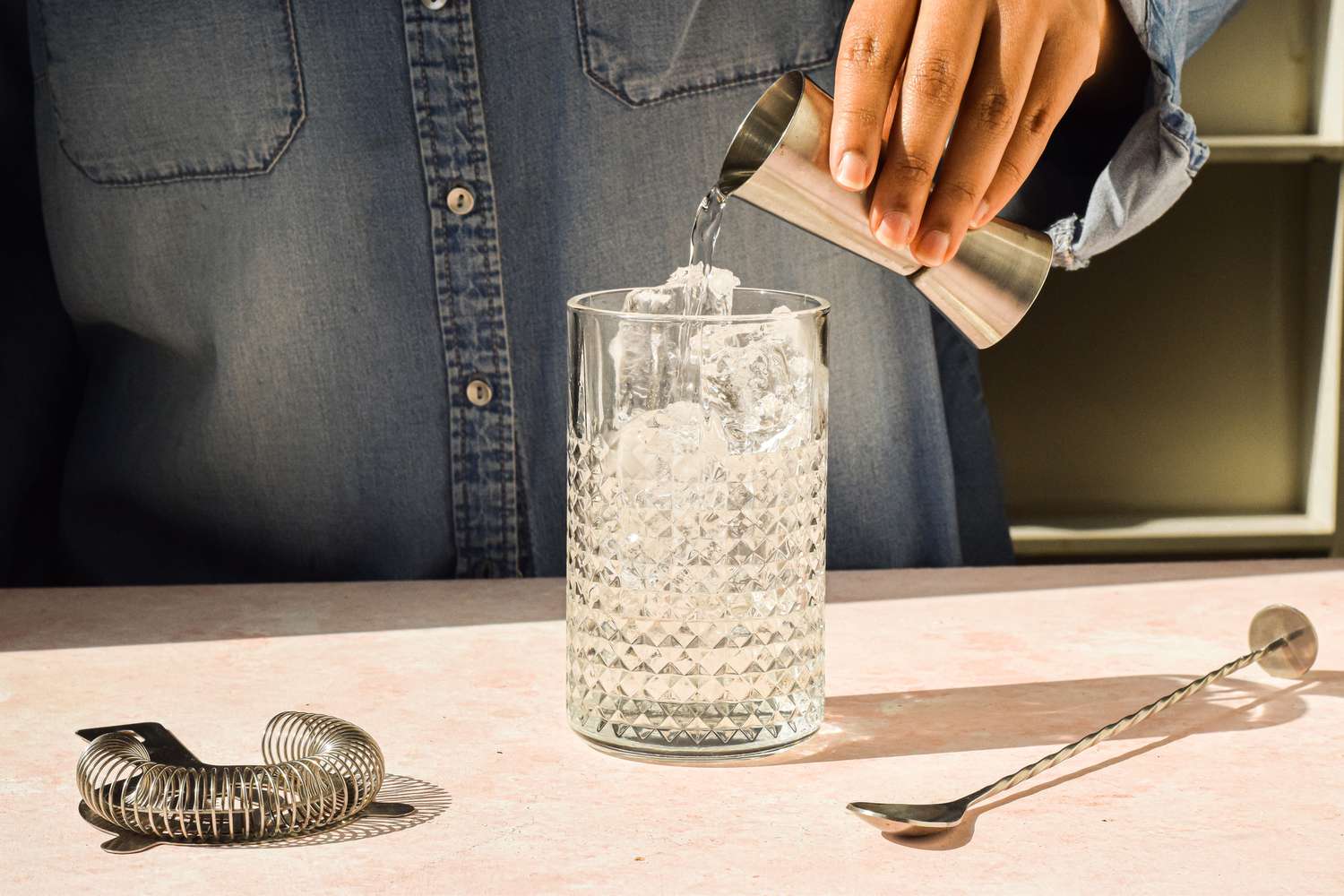 Pour ingredients for Classic Vodka Martini recipe into a mixing glass