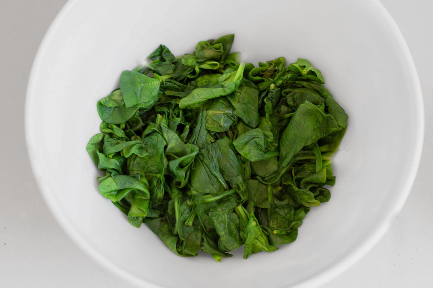 spinach wilted in a white bowl