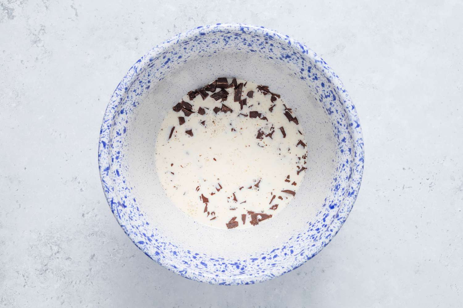 Heavy cream added to bowl of chocolate for homemade Cosmic Brownie ganache