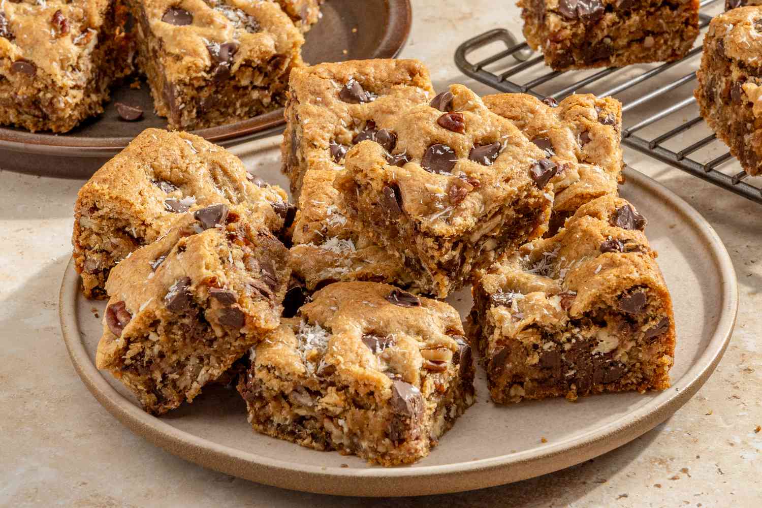 cowboy blondies on a plate with more on the cooling rack and plate in the background