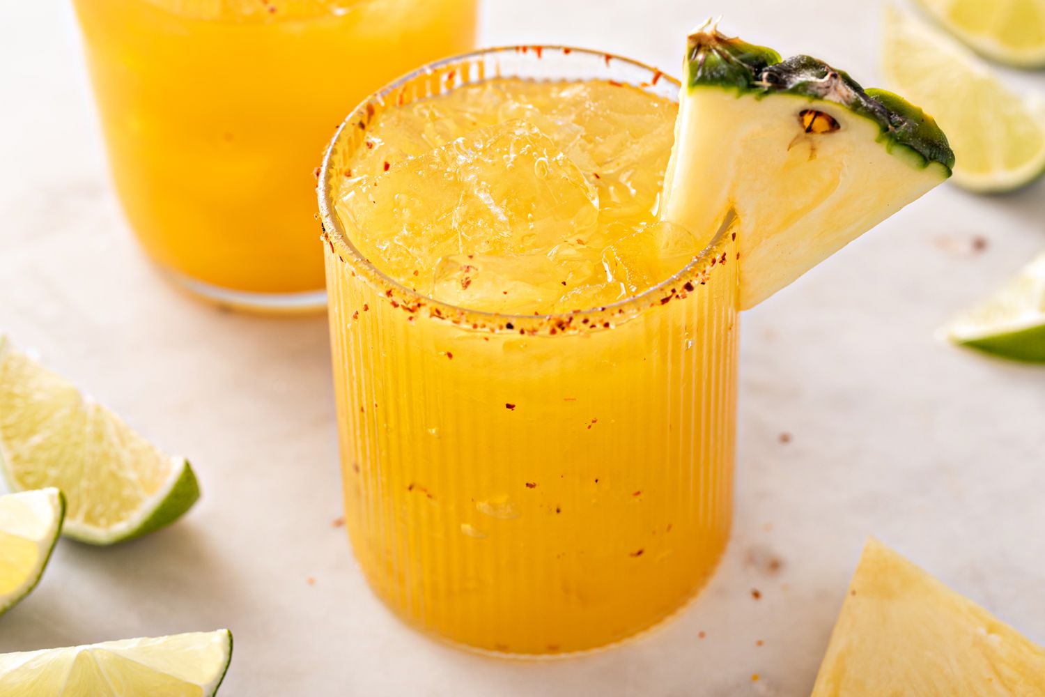 Close up of a pineapple margarita i a Tajin-rimmed glass