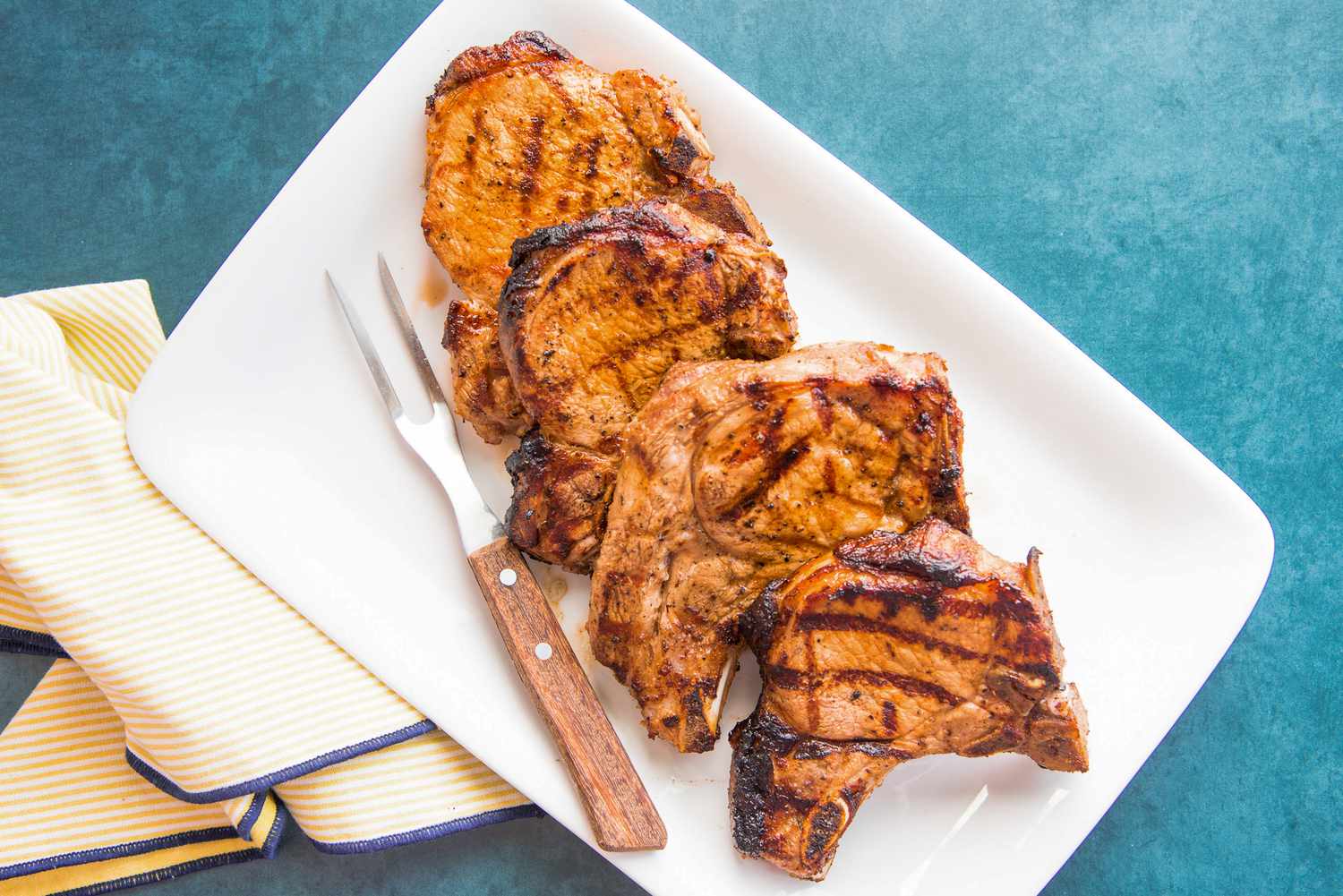 Grilled Pork Chops on Plate with Carving Fork