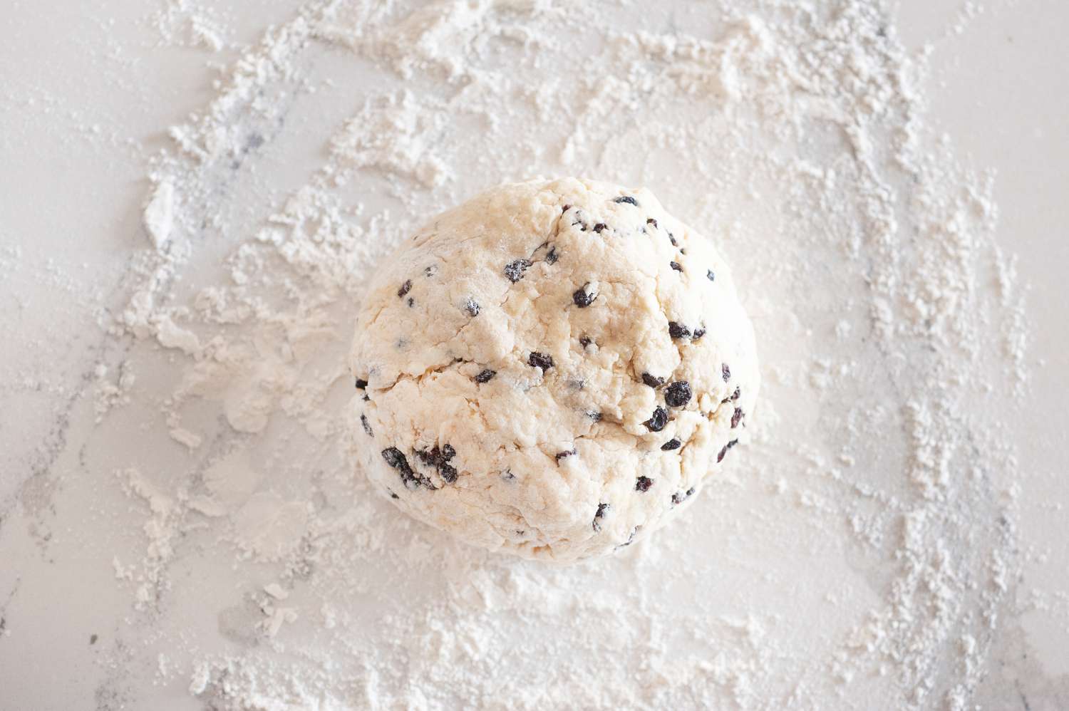 Dough for Easy Irish Scones in a ball on a floured counter.