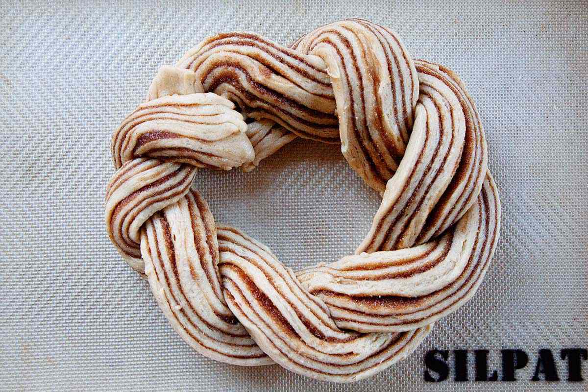 The best King Cake dough is shaped into a circle on a baking sheet.