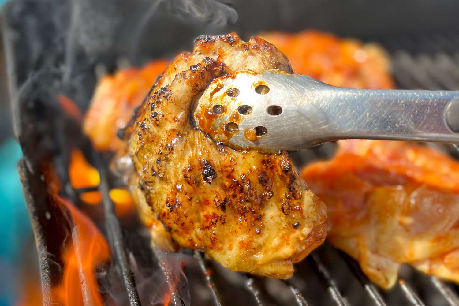 Tongs Holding Cooked Easy Grilled Gochujang Chicken Thighs