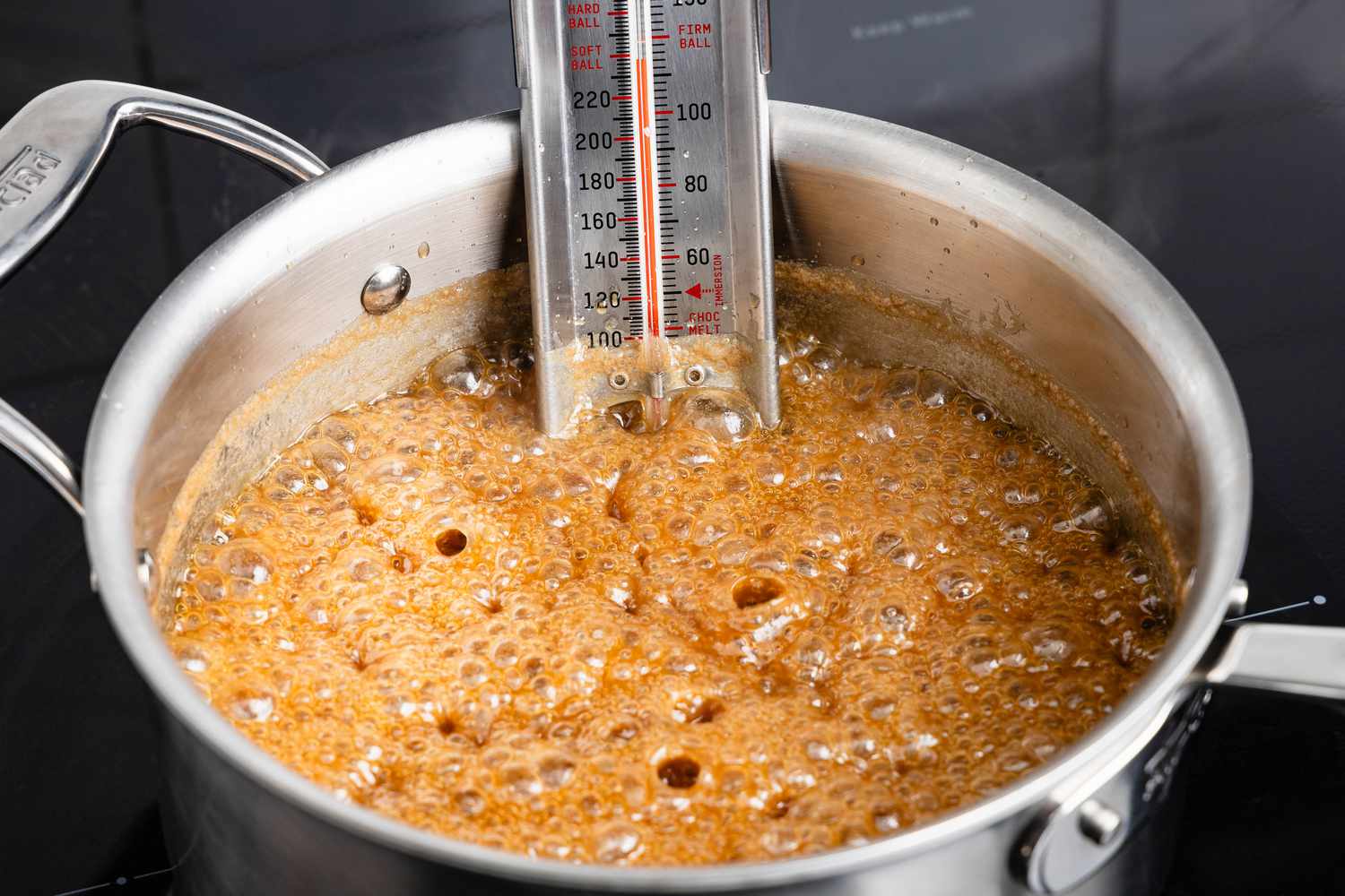 Penuche boiling in a sauce pan with a candy thermometer (reading about 238F) 