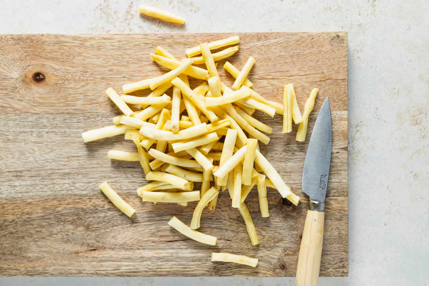Wax beans on a cutting board to make a wax beans recipe.