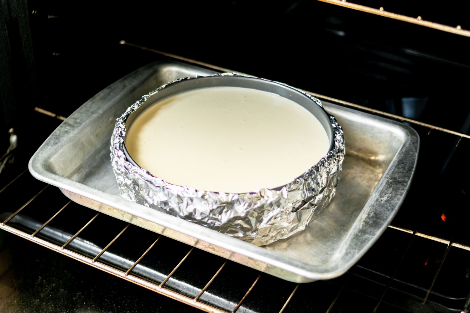 Cheesecake in a pan in the oven.