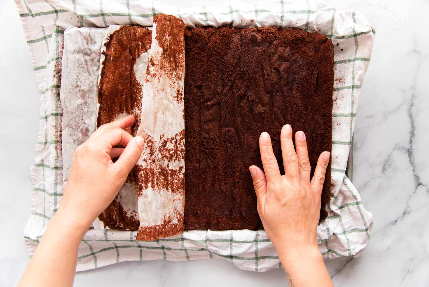 Unrolling chocolate swiss roll cake.