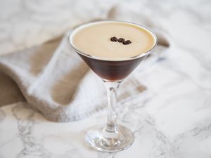 Side view of an Espresso Martini Drink on a marble background.