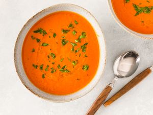 Pumpkin tomato soup garnished with herbs