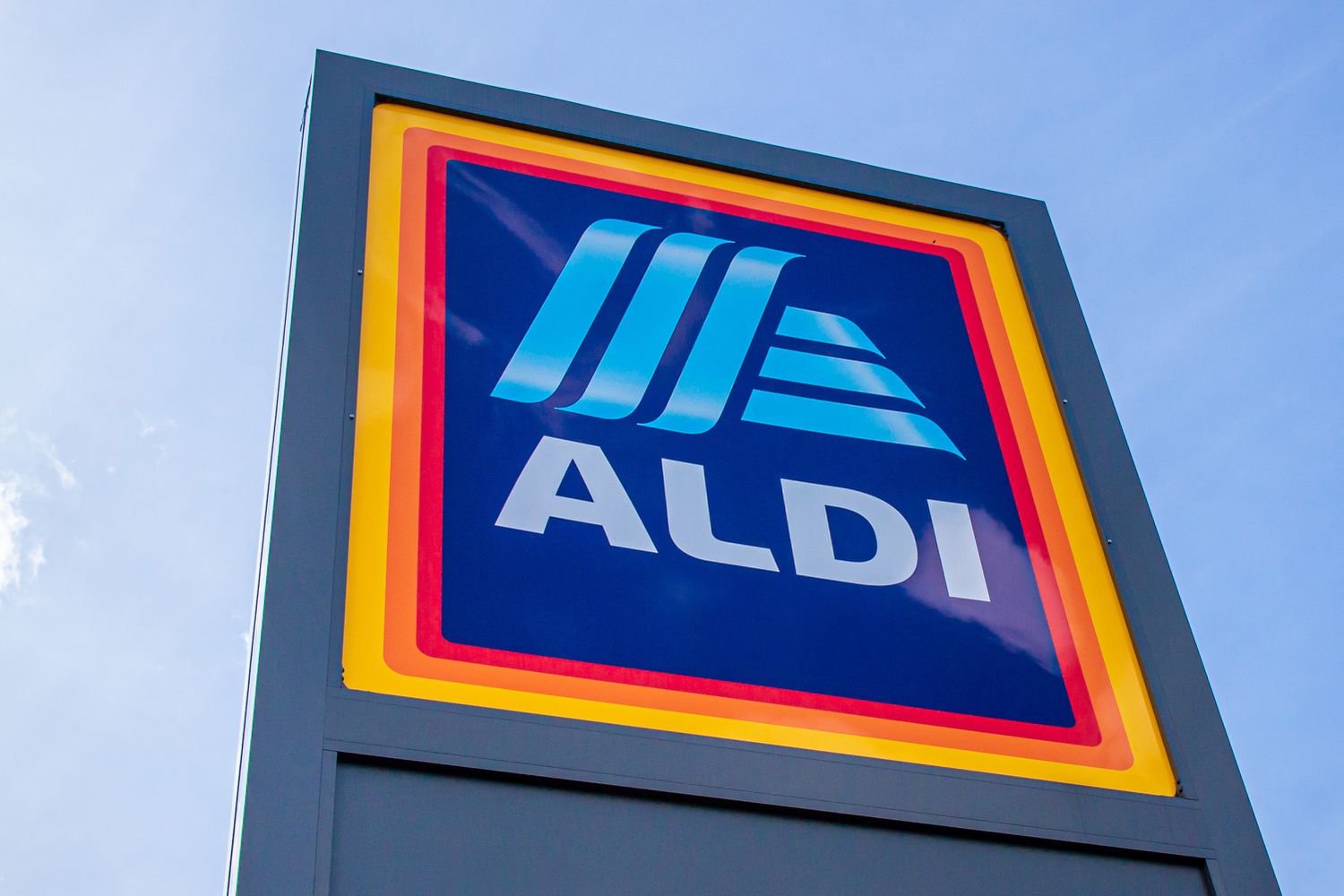 Image of a stand-alone Aldi store sign and logo against a blue sky