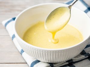 Bowl of Crème Anglaise with Some Dripping from a Spoon