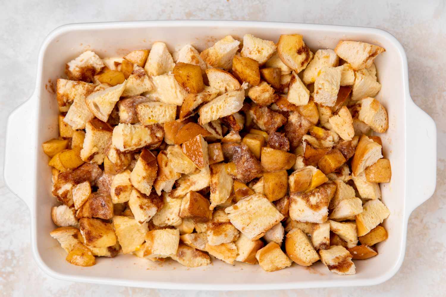 Apple Filling and Bread Pieces Mixed Together in a Casserole Dish 