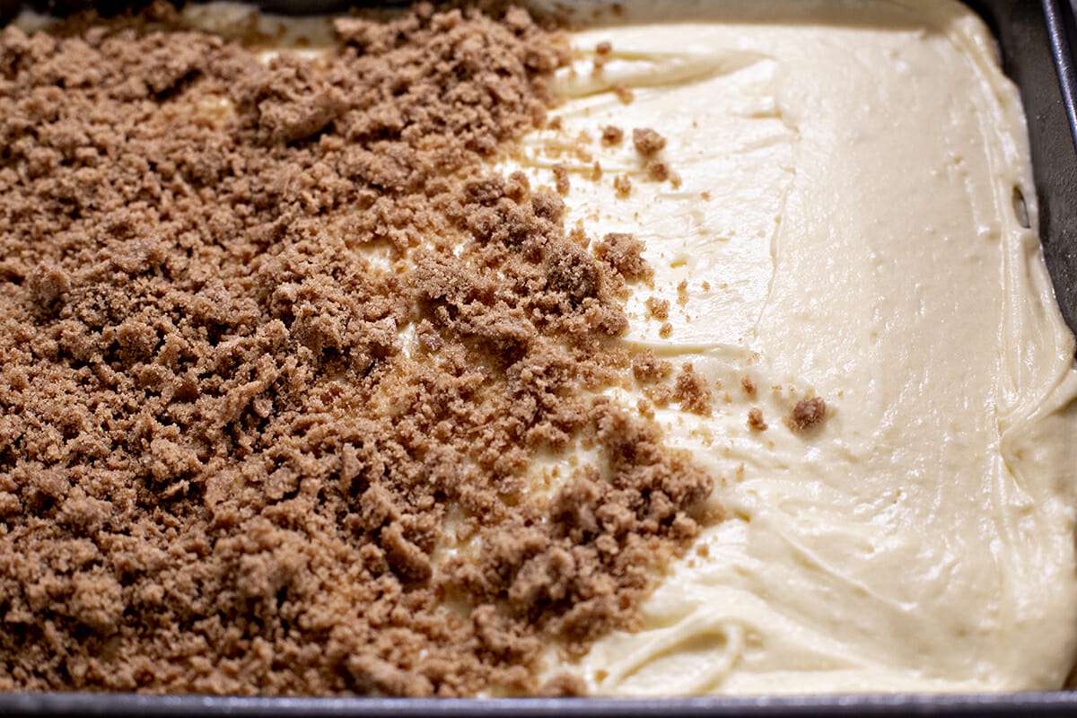 Cake batter partially covered in crumb topping