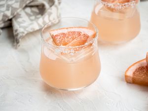 Two delicious grapefruit margaritas garnished with a grapefruit wedge.