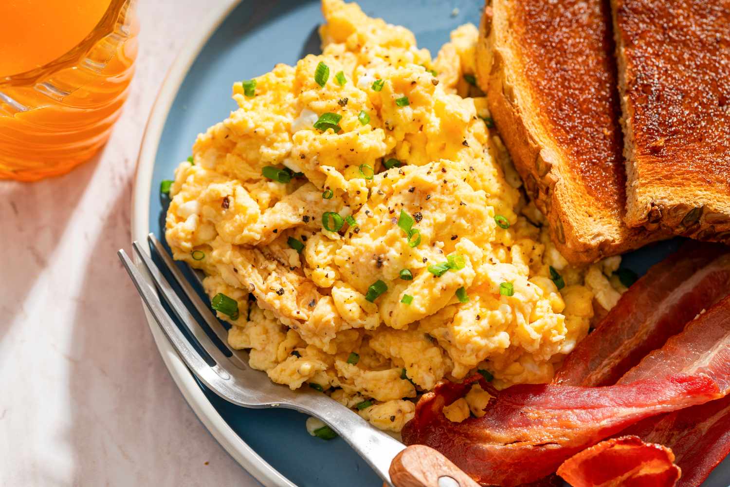 Plate with scrambled eggs toast and bacon
