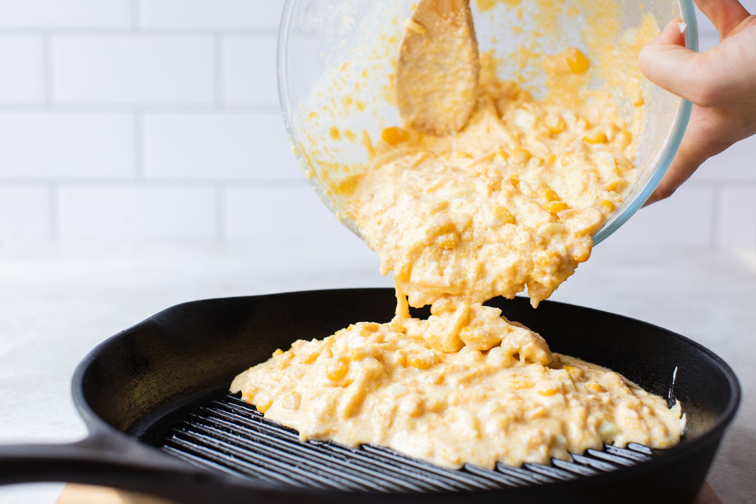 Cheesy Skillet Cornbread Batter Poured into Hot Cast Iron Skillet 