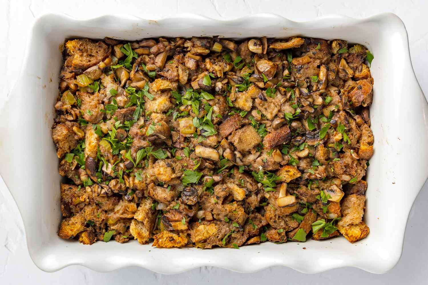Baked Vegan Mushroom Stuffing in Casserole Dish and Topped with Shredded Parsley