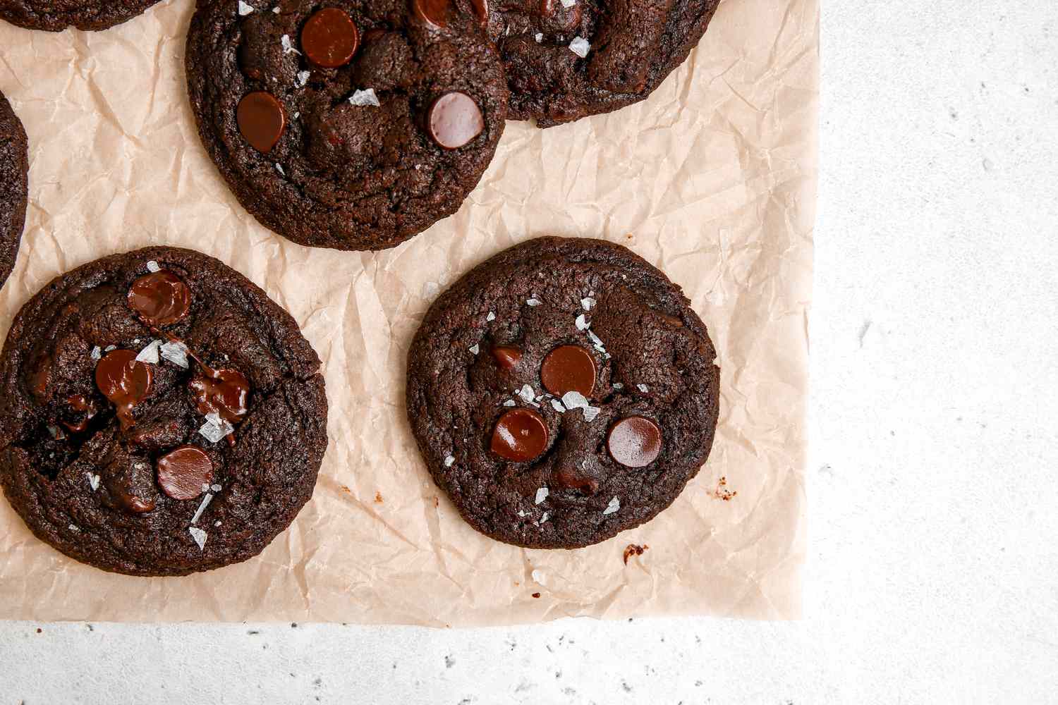 Chewy double chocolate cookies on a parchment lined baking sheet.