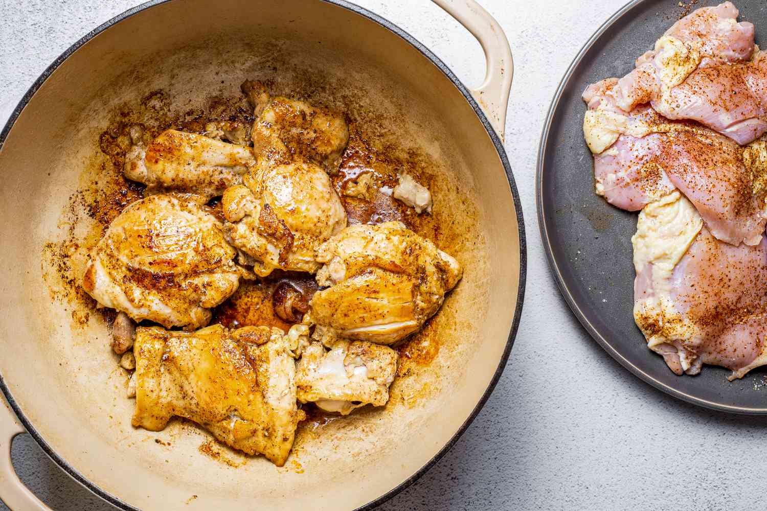 Chicken Thighs Seared in a Dutch Oven and Next to It, More Seasoned Chicken on a Plate for Chipotle Chicken Chowder Recipe