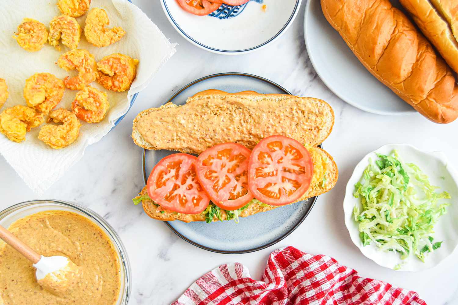 Building the Classic Shrimp Po Boy Sandwich: Tomatoes Added to Sandwich