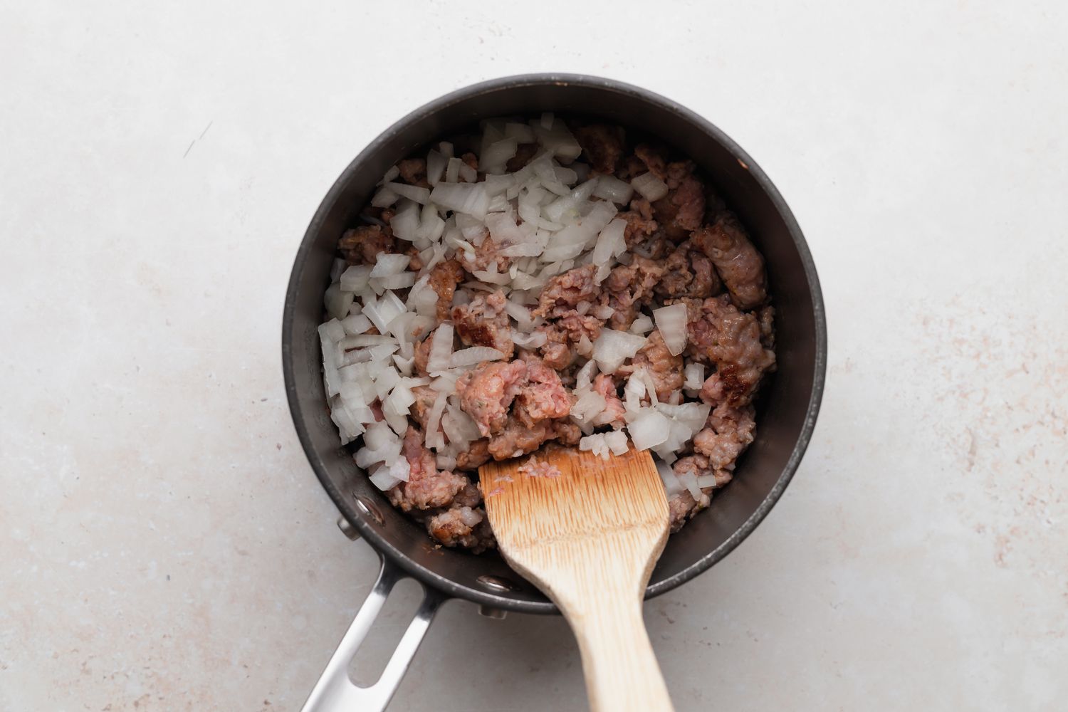 Browning sausage and onions to make a biscuits and gravy recipe