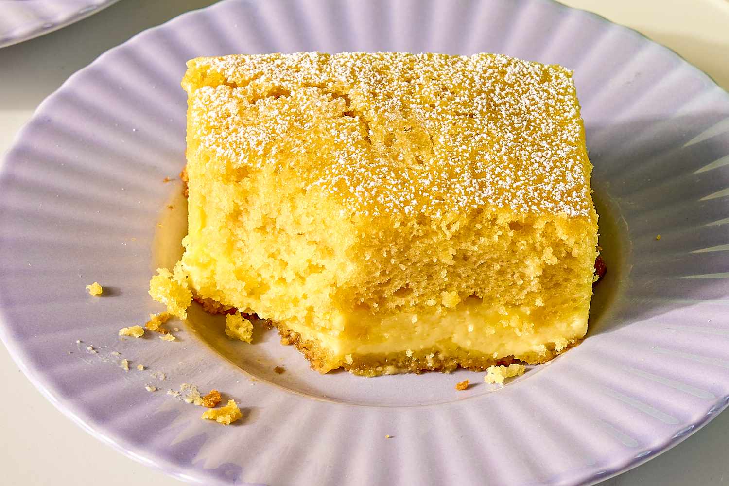 A slice of cake on a plate topped with powdered sugar