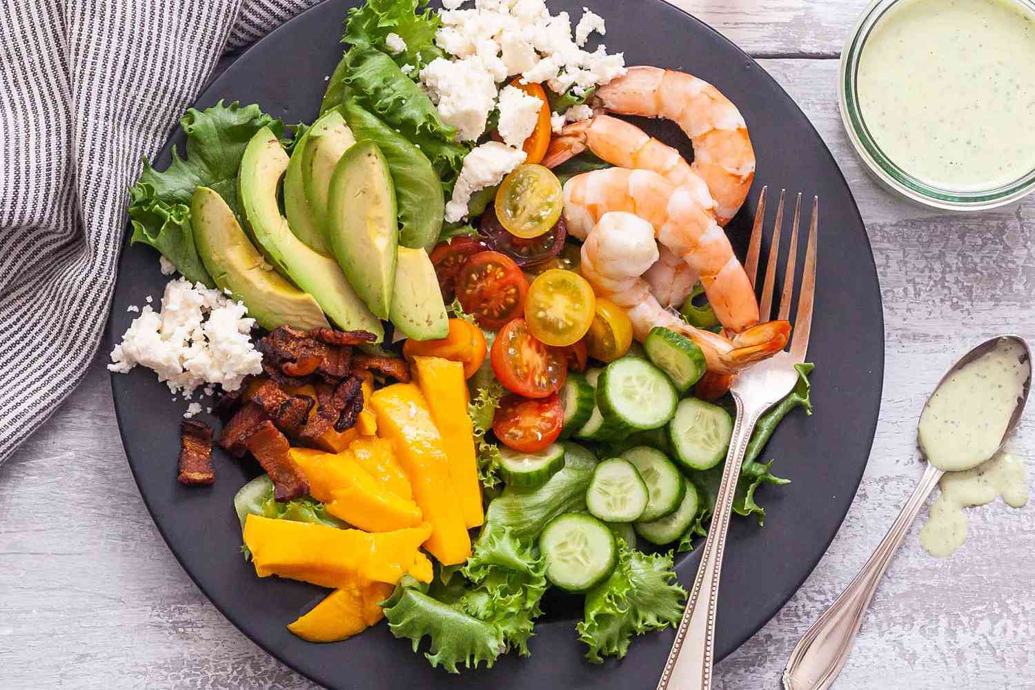 A dinner plate with shrimp cobb salad before it's dressed 