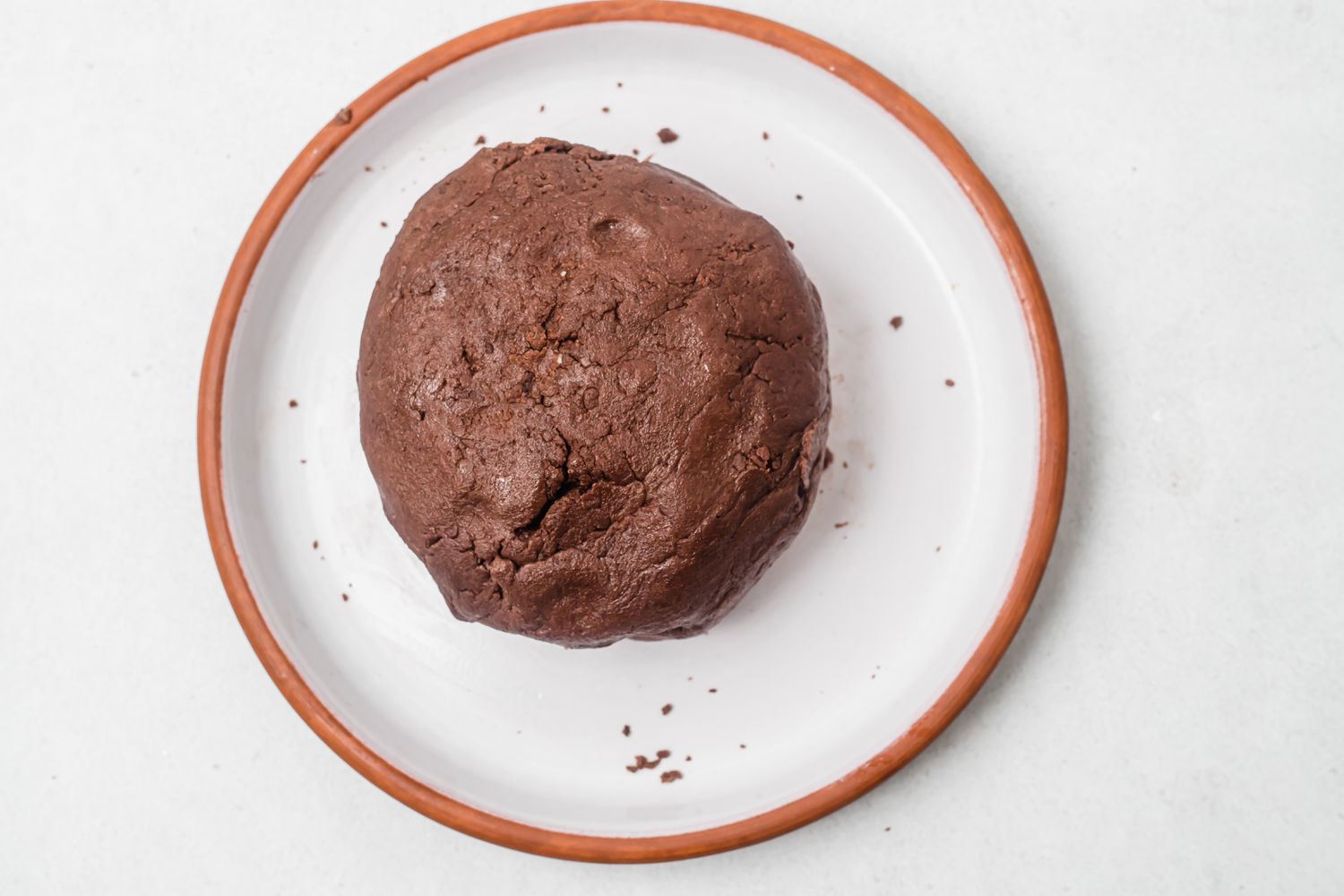 Dough for holiday chocolate and peppermint shortbread on a plate in a ball.