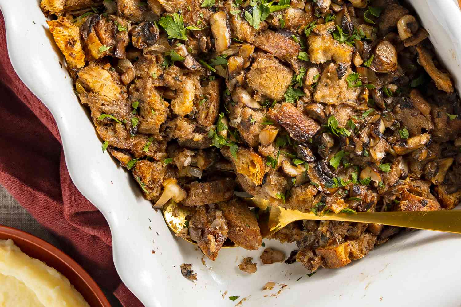 Stuffing in a baking dish, with a serving spoon scooping some stuffing out
