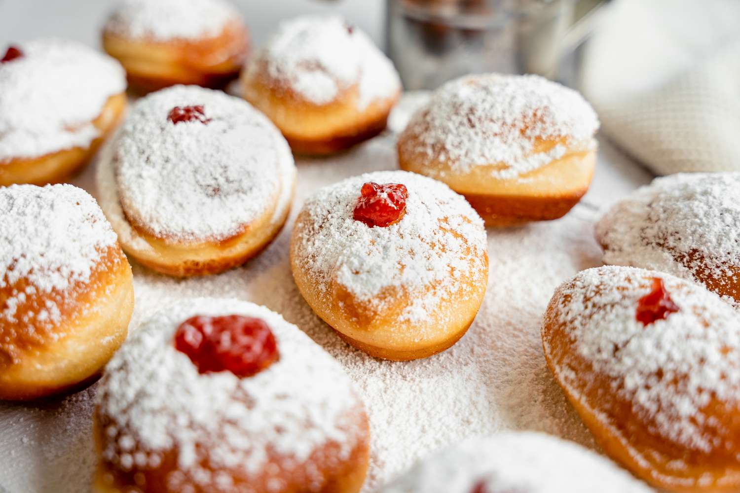 Sufganiyot (Israeli Jelly Donuts) on Parchment Paper Covered in Powdered Sugar