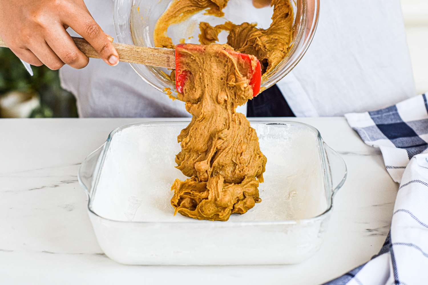 Scooping blondie batter into a baking dish