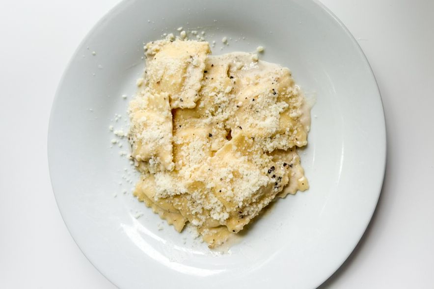 A plate of pasta topped with grated cheese