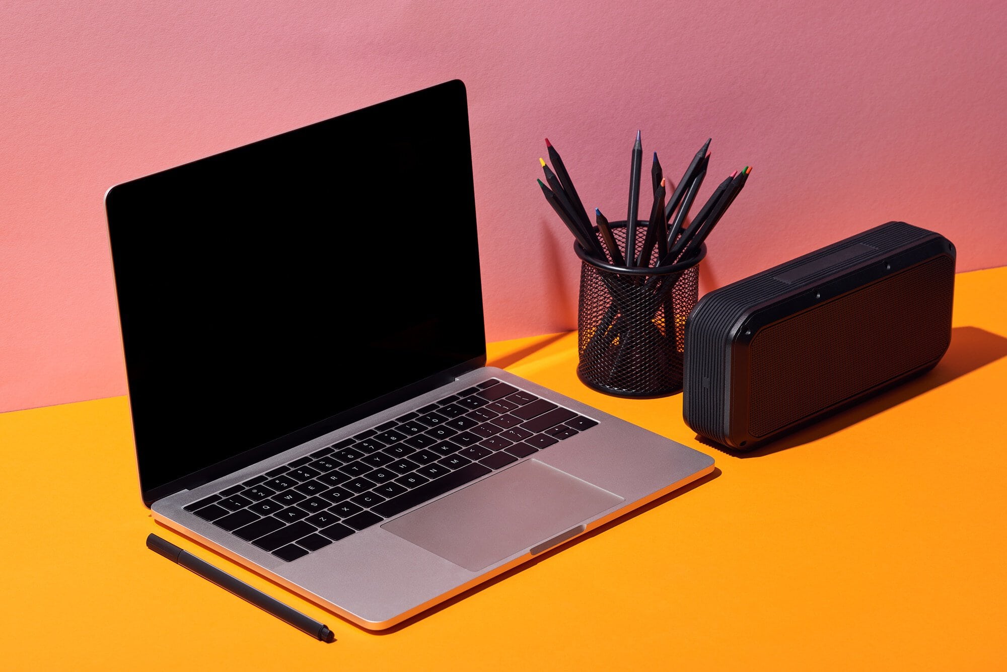 freelance jobs laptop on desk with pink and orange background
